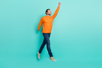Wall Mural - Full length profile portrait of cheerful man raise arm empty space hold imagine umbrella isolated on teal color background