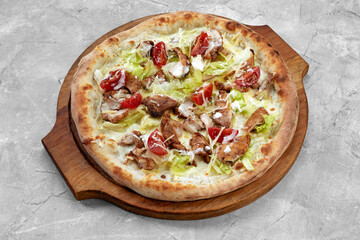 Wall Mural - Delicious pizza Caesar style with white sauce, chicken, parmesan, egg, cherry tomatoes and fresh lettuce at wooden background. Restaurant pizzeria menu with delicious taste pizza Caesar.