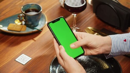 Woman using smartphone with chroma green screen, online menu in cafe. Scanning QR code in restaurant. Modern technology, ordering meal in application. Contactless touch-free payment in app.
