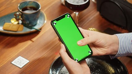 Woman using smartphone with chroma green screen, online menu in cafe. Scanning QR code in restaurant. Modern technology, ordering meal in application. Contactless touch-free payment in app.