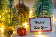 Happy New Year writing on greeting card with small house and lights background
