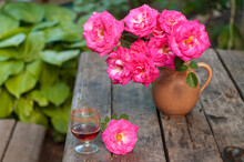 Pink Roses And Red Wine At Table