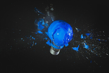 Wall Mural - blue light bulb exploding on black.