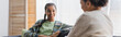 © LIGHTFIELD STUDIOS - smiling african american girl looking at blurred mother during conversation at home, banner