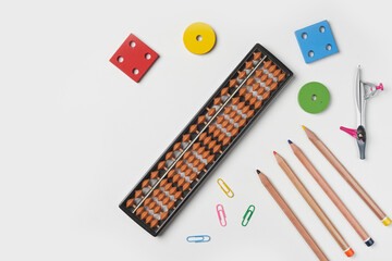 Creative lay out of mental mathematics items. Mental arithmetic for kids. School items for kids. Abacus with school supplies, drawing compass on colored background. Mental mathematics, math concept