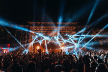 Silhouettes Of Concert Crowd In Front Of Bright Stage Lights On A Music Festival