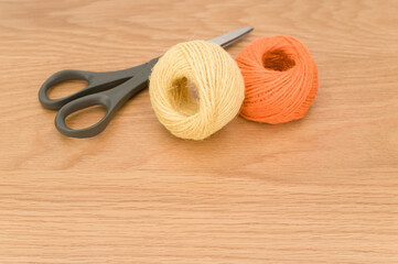 Poster - decorative rustic yellow orange yarn ball and scissors on a wooden background