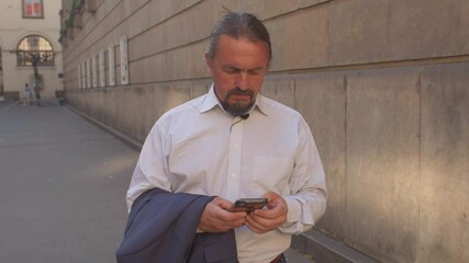 Poster - Portrait of a man with a phone outside. Set of messages with the help of hand fingers. Respectable businessman is busy with important business.