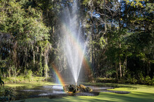 Photo Of A Fountain In A Park With A Double Rainbow Showing In The Water Spray