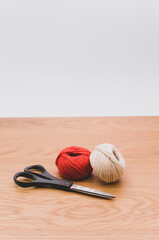 Poster - decorative rustic yarn ball and scissors on a wooden tabletop with copy space