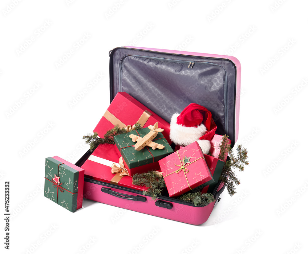 Suitcase with gift boxes, fir branches and Santa hat on white background. Christmas vacation concept