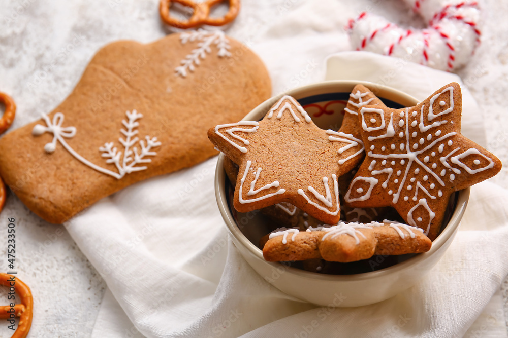 Bowl of tasty gingerbread cookies on light background