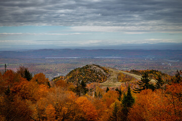 Poster - Mesmerizing landscape view with colorful autumn vegetation on the hills against a cloudy sky