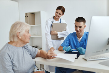 Wall Mural - elderly woman patient at hospital appointment nurse and doctor health care