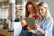 © NDABCREATIVITY - Happy smiling business women working together online on a tablet in office