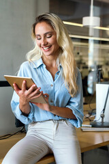 Portrait of happy successful woman working, websurfing on digital tablet in office