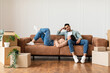 © Prostock-studio - Family relaxing on couch in new home with cardboard boxes