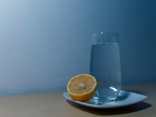 Wall Mural - Close-up picture of a glass of mineral water standing next to a lemon