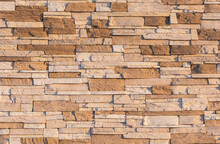 The Wall Is Faced With Brown Stone. Building Stone Texture