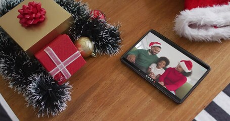 Sticker - Smiling african american family wearing santa hats on christmas video call on tablet