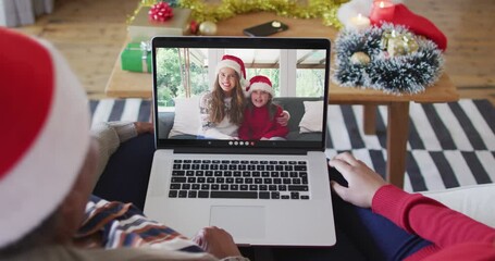 Sticker - African american mother and daughter using laptop for christmas video call with family on screen