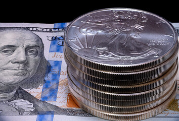 Wall Mural - Stack of U.S. Silver Eagle bullion coins on a hundred dollar bill