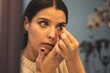 ©  Yistocking - A young, pretty girl puts on an animal-patterned contact lens at an optician.