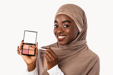 Wall Mural - Portrait of beautiful black muslim woman with hijab applying makeup