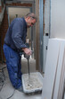 © Ladanifer - Senior constructor worker preparing tile adhesive mortar with a hand mixer.