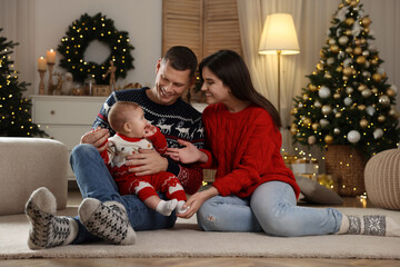 Wall Mural - Happy couple with cute baby in room decorated for Christmas