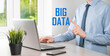 © Ivan - Businessman in a suit on a dark background holds the inscription BIG DATA. Storage Network Online Server Concept.Social network or business analytics representation