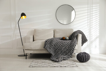 Wall Mural - Soft chunky knit blanket on sofa in living room. Interior design