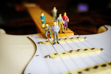 Closeup Shot Of People Figurines On An Electric Guitar