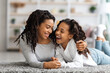 © Prostock-studio - Happy african american mother and daughter laying on carpet