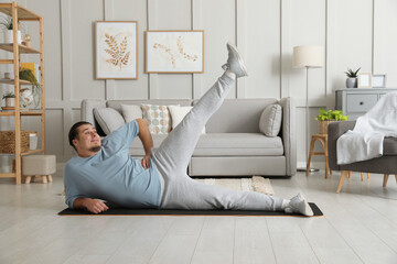 Sticker - Overweight man doing exercise on mat at home