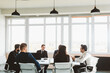 © xartproduction - Group of young business people working and communicating while sitting at the office desk together with colleagues sitting. business meeting