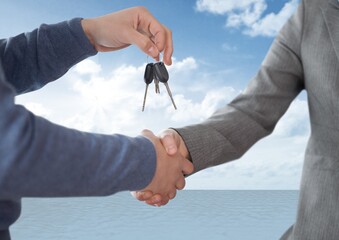 Mid section of dealer giving a man car keys against clouds in the sky