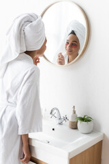 Wall Mural - cheerful african american woman in eye patches looking at mirror