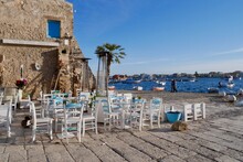 Lovely Outdoor Seating Area With Gorgeous View Of The Sea And Fishing Boats. Marzamemi, Province Syracuse, Sicily.