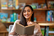 © Prostock-studio - Happy laitin woman thinking about future plans, writing list to do in notepad while sitting in cafeteria