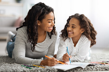 Wall Mural - Joyful mother and daughter drawing together at home