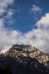 Sticker - Vertical shot of breathtaking cloudscape over rocky hills and mountains on a gloomy day