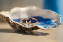 Close-up View Of Wedding Rings In A Shell On A Table With Wedding Decor At A Wedding Ceremony On The Beach,