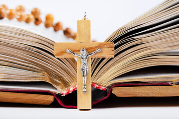 Bible with wooden cover and wooden rosary on white background