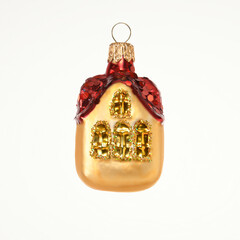 Vintage glass toy for decoration of Christmas tree. Golden fairy little house with red roof. Closeup, isolated on white background for your design.