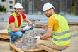 © zinkevych - Two workers stacking bricks looking at camera