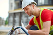 © zinkevych - Worker looking at construction tool sideways to camera
