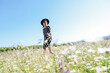 © dmitriisimakov - a beautiful woman walks in a field with chamomile flowers