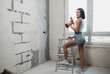 © kalinichenkod - beautiful girl in overalls with electric drill
