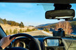 © keleny - Siberia, Russia - November 28, 2020: View from of car interior from side of driver to the road and nature landscape through the windshield